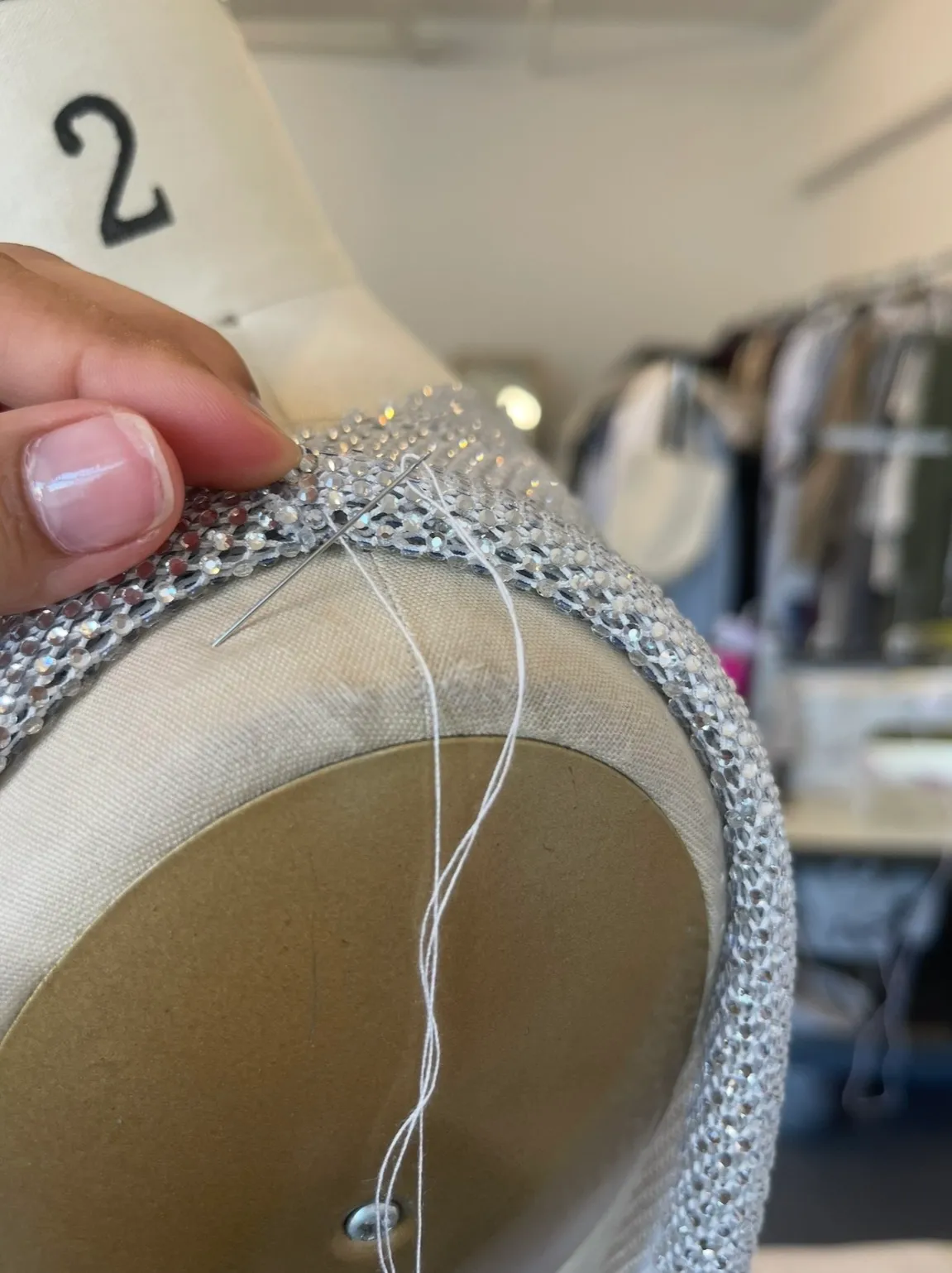 Hand-stitching the crystal-mesh shoulder